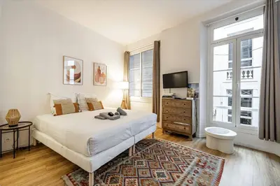 a white bedroom with a bed and a tv at 13 ANDRE1 - Hotel-Style Suite Studio 50m from Croisette in Cannes
