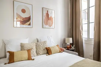 a bedroom with a bed with white sheets and pillows at 13 ANDRE1 - Hotel-Style Suite Studio 50m from Croisette in Cannes