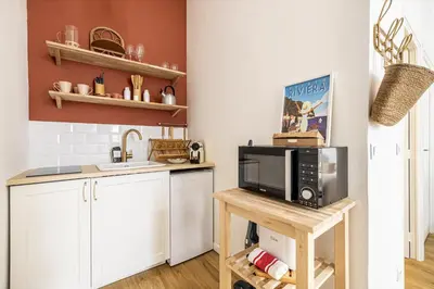 a kitchen with a microwave on a wooden table at 13 ANDRE1 - Hotel-Style Suite Studio 50m from Croisette in Cannes