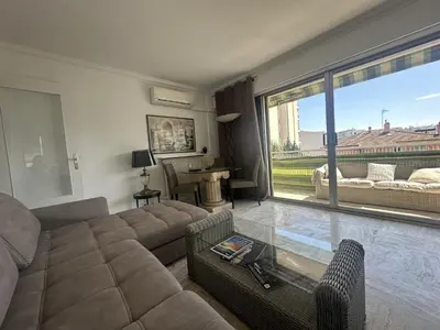 a living room with a couch and a large window at Abou1895 in Cannes