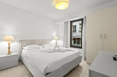 a white bedroom with a large bed and a window at VIP 2 chambres, 2 salles de bain et 2 WCs Palais des Festivals Croisette in Cannes