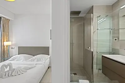 a bedroom with a bed and a shower and a sink at VIP 2 chambres, 2 salles de bain et 2 WCs Palais des Festivals Croisette in Cannes