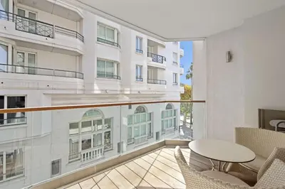 a balcony with a table and chairs and a building at VIP 2 chambres, 2 salles de bain et 2 WCs Palais des Festivals Croisette in Cannes