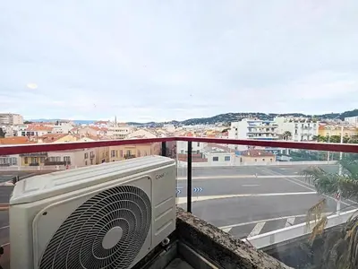 a fan on a balcony with a view of a city at Studio Etoile d'Or by Viva Riviera in Cannes