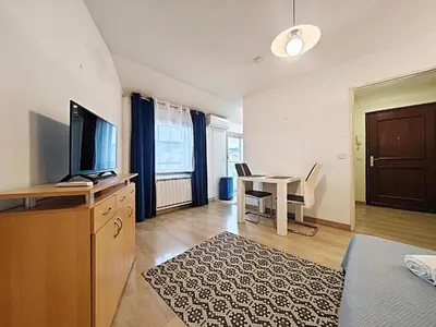 a living room with a television and a desk with a table at Studio Etoile d'Or by Viva Riviera in Cannes