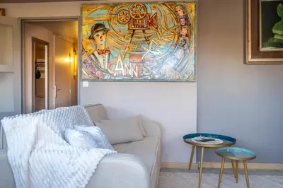 a living room with a couch and a painting on the wall at Apartment Cannes Felibriges in Cannes