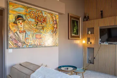 a living room with a couch and a painting on the wall at Apartment Cannes Felibriges in Cannes