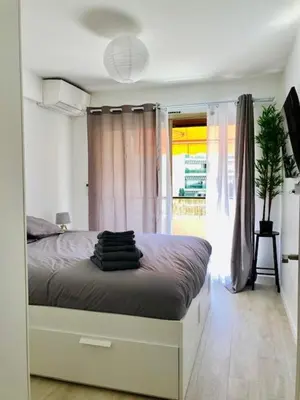 a bedroom with a bed and a large window at Résidence Cannes in Cannes