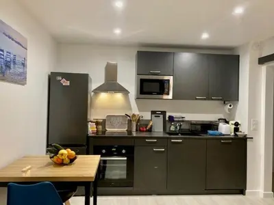 a kitchen with black cabinets and a wooden table at Résidence Cannes in Cannes