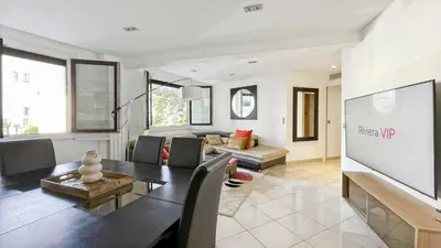 a living room with a table and a tv at Luxurious 3-Bedroom Apartment in Heart of Cannes in Cannes