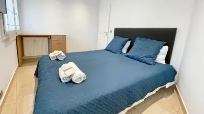 a bedroom with a large blue bed with towels on it at Luxurious 3-Bedroom Apartment in Heart of Cannes in Cannes