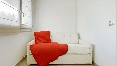 a white couch with a red blanket on it at Luxurious 3-Bedroom Apartment in Heart of Cannes in Cannes