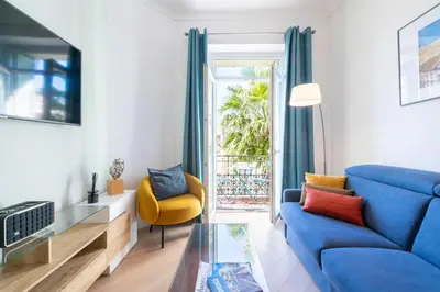 a living room with a blue couch and a glass table at Modern 2-Br Apartment with Balconies 3 Min from Palais des Festivals in Cannes