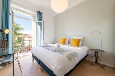 a bedroom with a large bed and a large window at Modern 2-Br Apartment with Balconies 3 Min from Palais des Festivals in Cannes