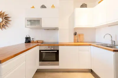 a kitchen with white cabinets and a sink at Modern 2-Br Apartment with Balconies 3 Min from Palais des Festivals in Cannes