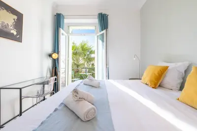 a bedroom with a large white bed with towels on it at Modern 2-Br Apartment with Balconies 3 Min from Palais des Festivals in Cannes