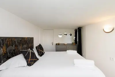 a bedroom with a large white bed with two pillows at Immogroom - Maisonnette - T3 - A/C - Wifi in Cannes