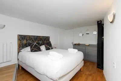 a bedroom with a large white bed and a dresser at Immogroom - Maisonnette - T3 - A/C - Wifi in Cannes