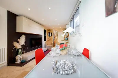 a dining room with a white table and red chairs at Immogroom - Maisonnette - T3 - A/C - Wifi in Cannes