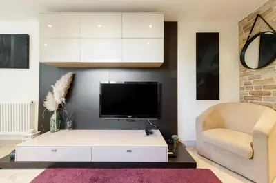 a living room with a tv and a white coffee table at Immogroom - Maisonnette - T3 - A/C - Wifi in Cannes