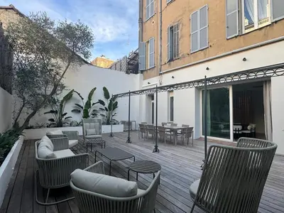 a patio with chairs and tables on a wooden deck at Appartement Centre Cannes in Cannes
