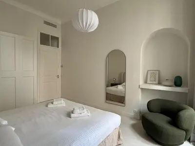 a bedroom with a bed and a chair and a mirror at Appartement Centre Cannes in Cannes