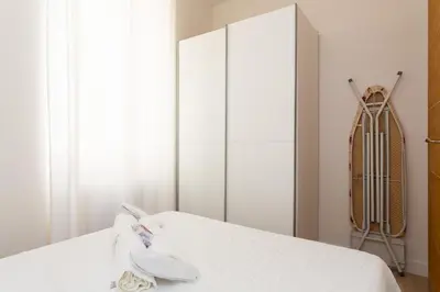 a bedroom with a white bed and a closet at Le Cosy YourHostHelper in Cannes