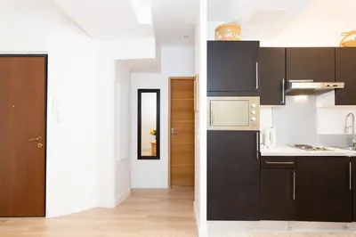 a kitchen with black cabinets and white counters at Le Cosy YourHostHelper in Cannes