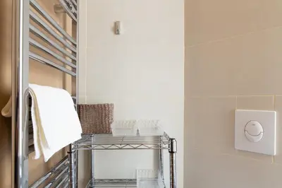 a bathroom with a towel rack and a mirror at Le Cosy YourHostHelper in Cannes