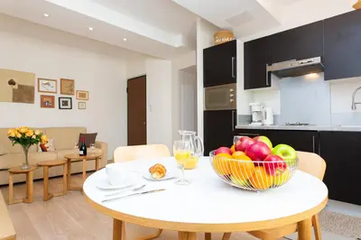 a kitchen with a table with a bowl of fruit on it at Le Cosy YourHostHelper in Cannes