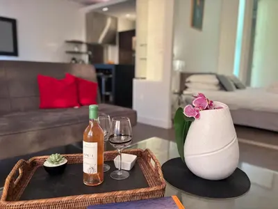 a living room with a table with a bottle of wine and glasses at 