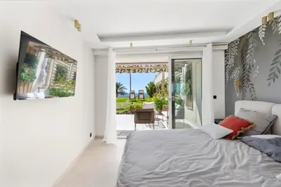 a bedroom with a bed and a view of a patio at Luxueux Appartement avec Jardin Suspendu Vue Mer 10 min du Palais Cannes in Cannes