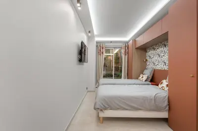 a bedroom with a bed and a window at Luxueux Appartement avec Jardin Suspendu Vue Mer 10 min du Palais Cannes in Cannes