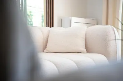 a white couch with a pillow on it at Luxueux Appartement avec Jardin Suspendu Vue Mer 10 min du Palais Cannes in Cannes