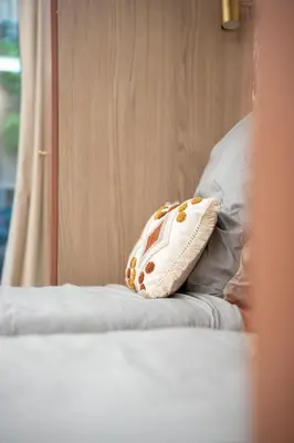 a pillow sitting on top of a bed at Luxueux Appartement avec Jardin Suspendu Vue Mer 10 min du Palais Cannes in Cannes