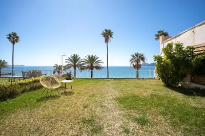 a park with a bench and palm trees and the ocean at Luxueux Appartement avec Jardin Suspendu Vue Mer 10 min du Palais Cannes in Cannes