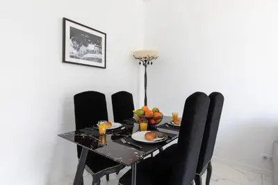 a dining room table with black chairs and fruit on it at Pelige 5 YourHostHelper in Cannes