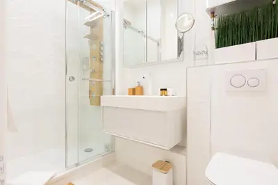 a white bathroom with a shower and a sink at Pelige 5 YourHostHelper in Cannes