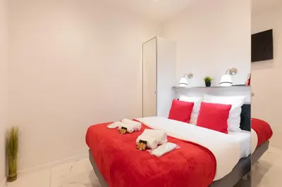 a bedroom with a large bed with red pillows at Pelige 5 YourHostHelper in Cannes