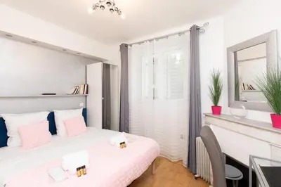 a bedroom with a bed and a desk and a mirror at Pelige 3 YourHostHelper in Cannes