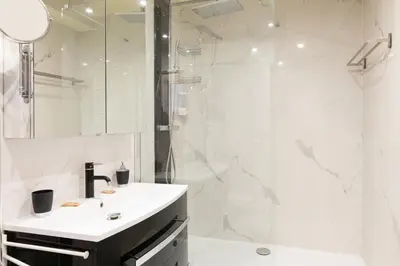 a white bathroom with a sink and a shower at Pelige 3 YourHostHelper in Cannes