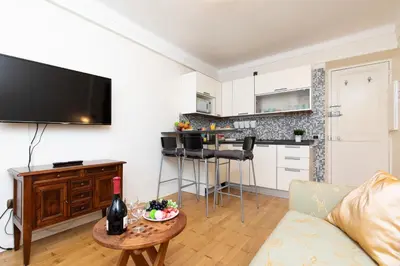 a living room with a couch and a table with a bottle of wine at Pelige 3 YourHostHelper in Cannes
