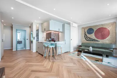 a kitchen and living room with a wooden floor at Bel appartement centre Cannes 1min de la Croisette in Cannes