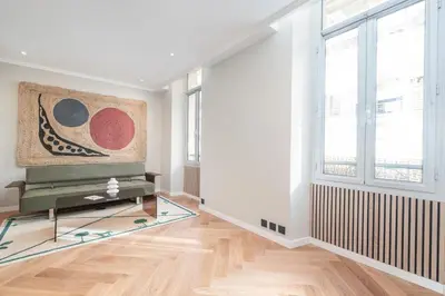 a living room with white walls and a large window at Bel appartement centre Cannes 1min de la Croisette in Cannes