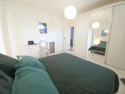 a bedroom with a green bed and a mirror at Palais Alexandre in Cannes
