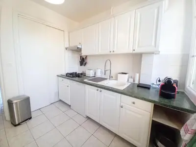 a small kitchen with white cabinets and a sink at Palais Alexandre in Cannes