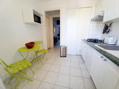 a kitchen with yellow chairs and a table in it at Palais Alexandre in Cannes