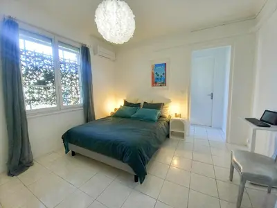 a bedroom with a bed and a large window at Palais Alexandre in Cannes