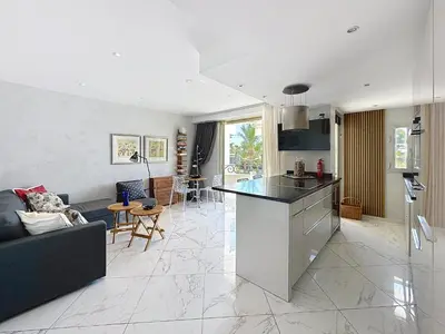 a kitchen and living room with a couch and a table at Stylish 1-bedroom apartment with sea view on La Croisette in Cannes