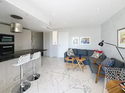 a living room with a couch and a table at Stylish 1-bedroom apartment with sea view on La Croisette in Cannes